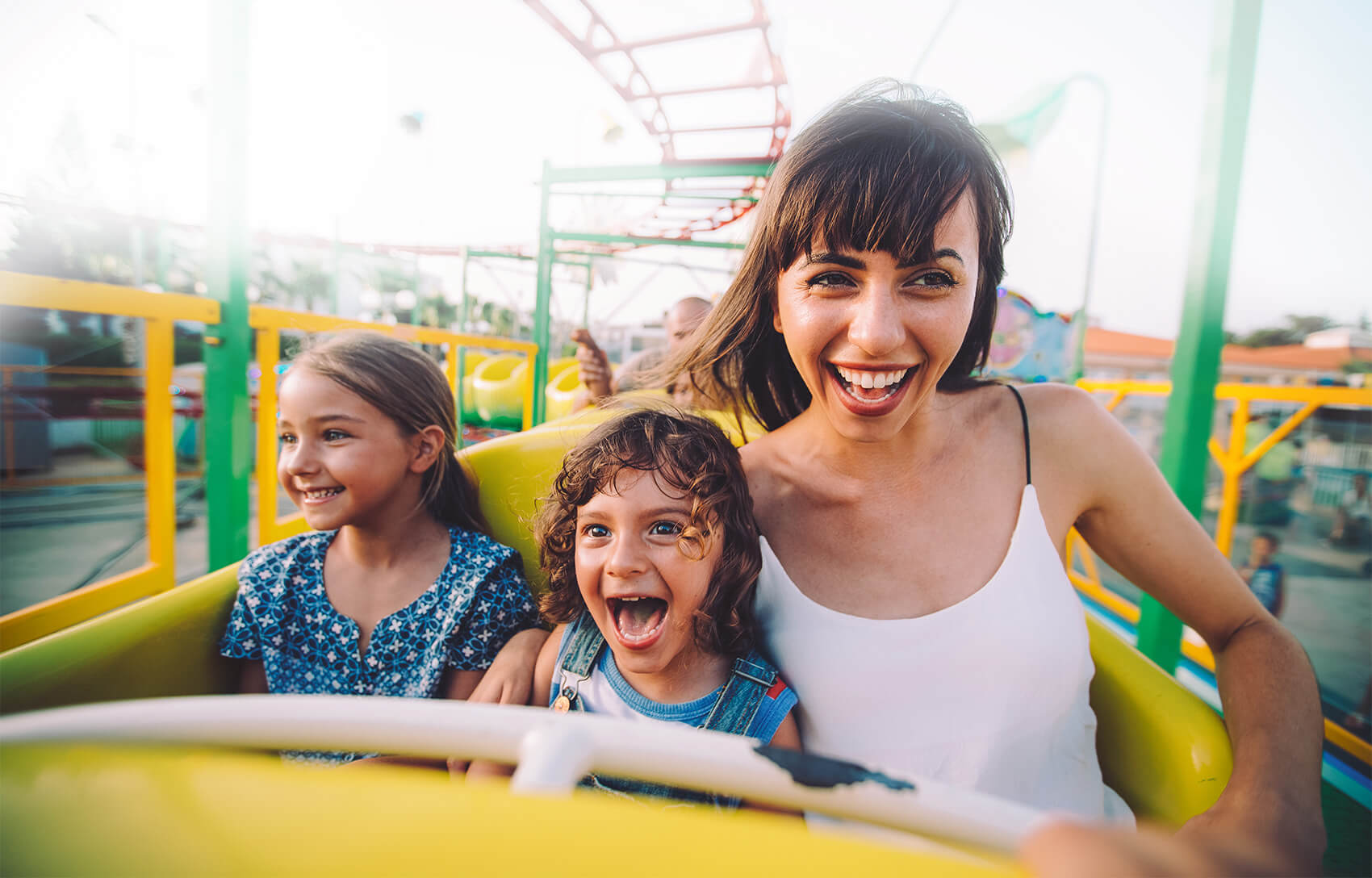 mother and two daughters riding a roller coaster