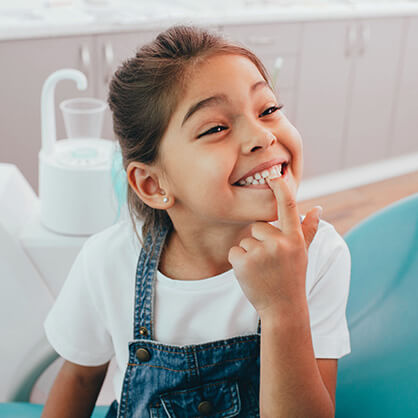 young girl pointing at her teeth